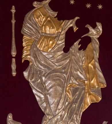 Zdjęcie nr 8: Obraz w kształcie stojącego prostokąta zamkniętego łukiem nadwieszonym, ujęty w złoconą profilowaną ramę dekorowaną kimationem. W centrum kompozycji, całopostaciowo i frontalnie ukazana Matka Boska z Dzieciątkiem w typie Niepokalanie Poczętej. Maria przedstawiona jako młoda kobieta o owalnej twarzy i dużych oczach ubrana w szaty królewskie: jasnoróżową suknię z długimi rękawami i białym kołnierzykiem, niebieski płaszcz oraz białą chustę i złotą, kameryzowaną koronę typu zamkniętego na głowie. W prawej ręce trzyma złote berło, na lewym przedramieniu podtrzymuje Dzieciątko Jezus. Stopy Marii, obute w sandały, są wsparte na sierpie księżyca. Dzieciątko przedstawione całopostaciowo, w pozycji siedzącej. Twarz okrągła z dużymi, szeroko otwartymi oczami i krótkim nosem, na głowie jasne i lekko kręcone włosy. Jezus prawą ręką błogosławi, w lewej trzyma glob ziemski. Wokół bioder luźno udrapowana biała tkanina. W dolnej części kompozycji, u stóp Marii klęczące dwie grupy ukazanych w pomniejszonej skali fundatorów. Z lewej strony obrazu klęczące postaci kobiety w niebieskich szatach i białej chuście na głowie, dojrzałego mężczyzny z ciemnobrązowej szacie i czerwonym płaszczu oraz nieco dalej kolejna postać kobieca w niebiesko-szarych szatach i białym nakryciu głowy. Z prawej strony obrazu klęcząca postać duchownego w sutannie i białej komży, za którą mężczyzna z krótkimi włosami i wąsem ubrany w jasnobrązowe szaty i dwie kolejne postaci męska i kobieca. Na dalszym planie rozległy pejzaż z widocznymi w oddali murami miejskimi. W górnej części kompozycji, na wysokości twarzy Marii dwie uskrzydlone główki anielskie. Kolorystyka obrazu ciemna, ciepła z dominacją brązów i czerwieni.

