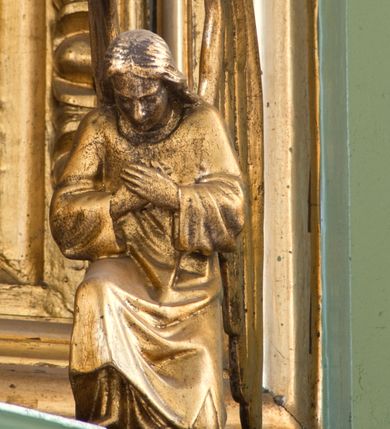 Zdjęcie nr 5: Tabernakulum z tronem wystawienia, jednokondycyjne o formach architektonicznych i wklęsło-wypukłym licu. Ujęte ustawionymi ukośnie, zdwojonymi, złoconymi kolumienkami wspartymi na wysokich cokołach. Kapitele kolumn kompozytowe, dźwigają odcinki pełnego belkowania wyłamanego w osiach podpór. Powyżej pełnoplastyczne, złocone figury klęczących aniołów. Drzwiczki tabernakulum złocone w kształcie stojącego prostokąta zamkniętego łukiem pełnym. Na licu płaskorzeźbiony kielich z hostią na tle glorii promienistej oraz kłosów zboża i winnych gron. Tron wystawienia o linii wypukłej z niszą ujętą płaskorzeźbioną, złoconą kotarą dekorowaną chwostami oraz muszlami palmetowymi. Tło wyłożone aksamitną, czerwoną tkaniną. W zwieńczeniu srebrzony Baranek Eucharystyczny spoczywający na księdze. Struktura tabernakulum malowana w odcieniu seledynowej zieleni, ornamentyka i załamania profili architektonicznych złocone.

