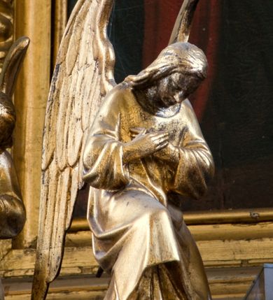 Zdjęcie nr 8: Tabernakulum z tronem wystawienia, jednokondycyjne o formach architektonicznych i wklęsło-wypukłym licu. Ujęte ustawionymi ukośnie, zdwojonymi, złoconymi kolumienkami wspartymi na wysokich cokołach. Kapitele kolumn kompozytowe, dźwigają odcinki pełnego belkowania wyłamanego w osiach podpór. Powyżej pełnoplastyczne, złocone figury klęczących aniołów. Drzwiczki tabernakulum złocone w kształcie stojącego prostokąta zamkniętego łukiem pełnym. Na licu płaskorzeźbiony kielich z hostią na tle glorii promienistej oraz kłosów zboża i winnych gron. Tron wystawienia o linii wypukłej z niszą ujętą płaskorzeźbioną, złoconą kotarą dekorowaną chwostami oraz muszlami palmetowymi. Tło wyłożone aksamitną, czerwoną tkaniną. W zwieńczeniu srebrzony Baranek Eucharystyczny spoczywający na księdze. Struktura tabernakulum malowana w odcieniu seledynowej zieleni, ornamentyka i załamania profili architektonicznych złocone.

