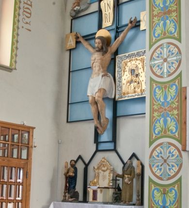 Zdjęcie nr 1: Ołtarz przyścienny, niearchitektoniczny, ze zwieńczeniem. Mensa kamienna w formie stołu wspartego na masywnych filarach. Na niej ustawione późnobarokowe tabernakulum z tronem wystawienia oraz figury świętych: św. Łukasza Ewangelisty oraz św. Benedykta z Nursji. Nastawa w formie ażurowej, metalowej konstrukcji w kształcie masywnego krzyża wspartego na trójdzielnej podstawie z prostokątów zakończonych trójkątnie. W polu ołtarza rzeźbiony krucyfiks umieszczony w prostokątnej, metalowej ramie na jasnobłękitnym tle. U szczytu pionowej belki krzyża titulus z apisem: IN/RI, na zakończeniach poziomej belki prostokątne tabliczki z greckimi literami: A i Ω. Po prawej stronie krucyfiksu umieszczony obraz z wizerunkiem Matki Boskiej Częstochowskiej w prostokątnej, bogato zdobionej akantem razie i złotej sukience. Zwieńczenie nastawy w formie barokowego szczytu o linii wklęsło-wypukłej mieszczącego w polu płaskorzeźbione przedstawienie Boga Ojca ukazującego się w obłokach w otoczeniu aniołów umieszczone na tle glorii promienistej. Szczyt ujęty jest spływami wolutowymi, na których ukazano siedzące putta. Ponad ołtarzem, na prostokątnym, błękitnym polu srebrzona gołębica Ducha Świętego.

