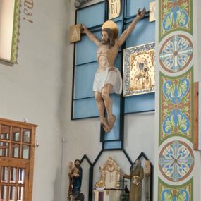 Zdjęcie nr 1: Ołtarz przyścienny, niearchitektoniczny, ze zwieńczeniem. Mensa kamienna w formie stołu wspartego na masywnych filarach. Na niej ustawione późnobarokowe tabernakulum z tronem wystawienia oraz figury świętych: św. Łukasza Ewangelisty oraz św. Benedykta z Nursji. Nastawa w formie ażurowej, metalowej konstrukcji w kształcie masywnego krzyża wspartego na trójdzielnej podstawie z prostokątów zakończonych trójkątnie. W polu ołtarza rzeźbiony krucyfiks umieszczony w prostokątnej, metalowej ramie na jasnobłękitnym tle. U szczytu pionowej belki krzyża titulus z apisem: IN/RI, na zakończeniach poziomej belki prostokątne tabliczki z greckimi literami: A i Ω. Po prawej stronie krucyfiksu umieszczony obraz z wizerunkiem Matki Boskiej Częstochowskiej w prostokątnej, bogato zdobionej akantem razie i złotej sukience. Zwieńczenie nastawy w formie barokowego szczytu o linii wklęsło-wypukłej mieszczącego w polu płaskorzeźbione przedstawienie Boga Ojca ukazującego się w obłokach w otoczeniu aniołów umieszczone na tle glorii promienistej. Szczyt ujęty jest spływami wolutowymi, na których ukazano siedzące putta. Ponad ołtarzem, na prostokątnym, błękitnym polu srebrzona gołębica Ducha Świętego.

