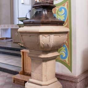 Zdjęcie nr 1: Chrzcielnica ustawiona na prostopadłościennej podstawie.  Profilowany cokół o przekroju prostokąta o ściętych narożach, trzon o takim samym przekroju ujęty u góry i u dołu profilowanymi wałkami. Czara spłaszczona o przekroju czworoboku o ściętych narożach; z wylewem. Pola z płycinową dekoracją peudomaswerkową. Pokrywa drewniana o dekoracji analogicznej jak czara, zwieńczona pełnoplastyczną, rzeźbioną sceną Chrztu Chrystusa.
