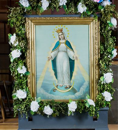 Zdjęcie nr 1: Feretron dwustronny, z prostopadłościenną podstawą z otworami na drążki. Na podstawie obrazy z przedstawieniem Matki Boskiej z Dzieciątkiem w typie Częstochowskiej oraz Matki Boskiej Niepokalanie Poczętej ujęte drewnianą, złoconą ramą. 
Matka Boska z Dzieciątkiem w typie Częstochowskiej Maria została ukazana w półpostaci, z Dzieciątkiem na lewym ramieniu, wskazując na nie drugą ręką. Patrzy na widza, ma duże, ciemne oczy, wąski nos i niewielkie usta; na prawym policzku dwa, równoległe nacięcia. Jest ubrana w czerwoną suknię w z wąskimi rękawami, obwiedzioną złotem przy szyi i przy mankietach, na którą ma zarzucony zielony maforion dekorowany złotym ornamentem roślinnym i lamowany taśmą ze szlachetnymi kamieniami. Dzieciątko prawą rękę unosi w geście błogosławieństwa, w lewej trzyma zamkniętą księgę. Ma owalną twarz, ciemne oczy, niewielki nos i usta. Jest ubrane w długą, czerwoną, dekorowaną drobnym ornamentem sukienkę z krzyżem łacińskim na piersi. Obie postacie mają na głowach zamknięte korony podtrzymywane przez anioły, a wokół złocone nimby. Tło jednolite, jasnozielone. 
Na drugim obrazie przedstawiono Matkę Boską w całej postaci, stojącą na ziemskim globie, lewą stopą depczącą węża, z półksiężycem przed stopami. Obie ręce ma rozłożone do boków, biją z nich w dół świetliste promienie, głowę skłania w prawo.  Ma owalną, delikatną twarz, spogląda przed siebie, ma szeroko otwarte oczy, wąski nos i niewielkie, czerwone usta oraz przykryte białym welonem długie włosy opadające na plecy. Na głowie korona, wokół niej wieniec z 12 gwiazd. Matka Boska jest ubrana w długą, białą suknię przewiązaną w talii paskiem oraz niebieski płaszcz lamowany złotem, zarzucony na plecy i spięty na dekolcie; stopy bose. Tło jasnoniebieskie, przechodzące dołem w skłębione obłoki. 
