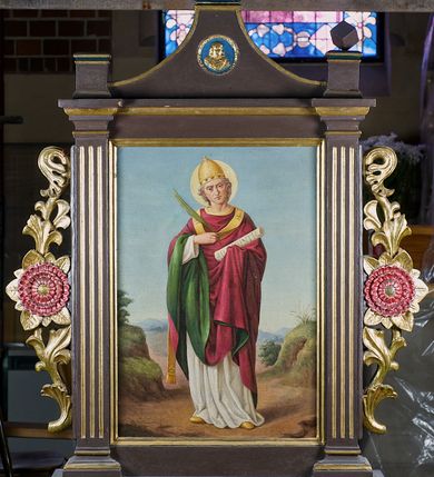 Zdjęcie nr 2: Feretron drewniany w prostej złoconej i malowanej ramie. Pole obrazowe ujęte dwoma kanelowanymi pilastrami. Zwieńczenie w formie łuku kotarowego z krzyżem na osi; w nim medalion z popiersiem Marii, poniżej dwa skrzyżowane młotki. Po bokach rzeźbione uszy z wici roślinnej i rozwiniętych kwiatów. Na awersie całopostaciowe przedstawienie św. Barbary na tle pejzażu, z wieżą po lewej stronie. Święta ukazana została w żółtej sukni, okryta niebieskim, podbitym na różowo, spiętym pod szyją płaszczem, z koroną na głowie. Lewą ręką przytrzymuje oparty o ziemię miecz, a prawą księgę oraz kielich z hostią. Na podstawie feretronu napis „Ś(więta) Barbaro / Módl się za nami”. 
Na rewersie całopostaciowe przedstawienie św. Klemensa na tle pejzażu. Święty został ukazany albie czerwonym ornacie podbitym zielenią, z tiarą na głowie i paliuszem na piersi. W prawej ręce trzyma liść palmowy, a w lewej zwój z napisem „AD CORINTHIOS”, wokół głowy ma złoty nimb. Na podstawie napis „Ś(więty) Klemensie / Módl się za nami”.