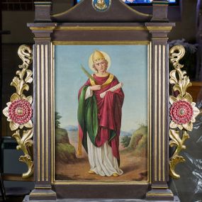 Zdjęcie nr 1: Feretron drewniany w prostej złoconej i malowanej ramie. Pole obrazowe ujęte dwoma kanelowanymi pilastrami. Zwieńczenie w formie łuku kotarowego z krzyżem na osi; w nim medalion z popiersiem Marii, poniżej dwa skrzyżowane młotki. Po bokach rzeźbione uszy z wici roślinnej i rozwiniętych kwiatów. Na awersie całopostaciowe przedstawienie św. Barbary na tle pejzażu, z wieżą po lewej stronie. Święta ukazana została w żółtej sukni, okryta niebieskim, podbitym na różowo, spiętym pod szyją płaszczem, z koroną na głowie. Lewą ręką przytrzymuje oparty o ziemię miecz, a prawą księgę oraz kielich z hostią. Na podstawie feretronu napis „Ś(więta) Barbaro / Módl się za nami”. 
Na rewersie całopostaciowe przedstawienie św. Klemensa na tle pejzażu. Święty został ukazany albie czerwonym ornacie podbitym zielenią, z tiarą na głowie i paliuszem na piersi. W prawej ręce trzyma liść palmowy, a w lewej zwój z napisem „AD CORINTHIOS”, wokół głowy ma złoty nimb. Na podstawie napis „Ś(więty) Klemensie / Módl się za nami”.