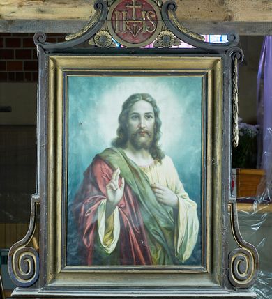 Zdjęcie nr 1: Feretron dwustronny, z prostopadłościenną podstawą z otworami na drążki. Na podstawie obrazy z przedstawieniem Chrystusa Błogosławiącego oraz Matki Boskiej z Dzieciątkiem otoczone drewnianą, profilowaną ramą zdobioną po bokach spłaszczonymi wolutami i zwieńczoną medalionem z monogramami „IHS” po jednej i „MARYA” po drugiej stronie, nad którym znajduje się zamknięta korona. Medalion ujmują c-kształtne elementy, a przestrzeń pod nimi wypełniają rozwinięte kwiaty.   
Na awersie Chrystus w półpostaci, który lewą rękę przyciska do piersi, a prawą unosi w geście błogosławieństwa. Na owalną twarz, duże ciemne oczy, wąski nos, niewielkie usta, wąsy oraz dzielącą się w dwa pukle brodę. Długie falowane włosy opadają mu na barki. Jest ubrany w żółtą suknię, przez prawy bark ma przerzucony czerwony płaszcz z zielonym podbiciem, wywinięty, łamiący się w obszerne fałdy. Wokół głowy postaci świetlisty nimb; tło stanowią niebieskie, skłębione obłoki. 
Na rewersie Matka Boska z Dzieciątkiem na prawym ramieniu, w półpostaci, frontalnie, z głową delikatnie przechyloną w prawo, lewą ręką przytrzymując Jezusa. Ma owalną twarz o delikatnych rysach, półprzymknięte oczy, wąski nos i szerokie usta, na głowie dekorowany pasem haftu, biały welon. Ubrana jest w czerwoną suknię z wąskimi rękawami i niebieski, podbity złotem płaszcz wywijający się przy prawej ręce. Dzieciątko siedzi, zwrócone w trzech czwartych w lewo, prawą ręką błogosławi, lewą dotyka dłoni Marii. Ma owalną, pulchną twarz o niebieskich oczach, małym nosie i ustach oraz jasne, falowane włosy. Jest ubrane w sukienkę białą górą, beżową dołem i przewiązaną fioletową szarfą w pasie; stopy bose. Postacie zostały ukazane na tle kamiennej balustrady, ponad którą widać rozłożyste drzewo i fragment ogrodu z kwitnący krzakiem róż po prawej stronie. 
