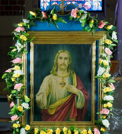 Zdjęcie nr 1: Feretron dwustronny, z prostopadłościenną podstawą z otworami na drążki. Na podstawie obrazy z przedstawieniem Najświętszego Serca Marii i Najświętszego Serca Jezusa otoczone drewnianą, profilowaną ramą zwieńczoną krzyżem łacińskim ujętym wolutami.
Na awersie Matka Boska została ukazana w półpostaci, frontalnie, patrząc przed siebie. Ma jasną karnację, rysy twarzy delikatne, oczy ciemne; ciemne, falowane włosy opadają jej na ramiona. Jest ubrana w białą lamowaną pod szyją złotem suknię, jasny, złocony na brzegach i opadający na barki welon, a na ramiona ma zarzucony błękitny, podbity jasnym materiałem płaszcz przechodzący na skos do prawego biodra. Prawą rękę wyciąga przed siebie, lewą wskazuje na widoczne na piersi gorejące serce oplecione różanym wieńcem. Tło przedstawienia ciemne, rozjaśnia się delikatnie wokół głowy Marii.  
Na rewersie ukazany w ten sam sposób Chrystus, który prawą rękę unosi w geście błogosławieństwa, a lewą wskazuje na oplecione koroną cierniową, płonące serce zwieńczone krzyżem. Jest ubrany w białą tunikę z długimi rękawami i  przerzucony przez lewe ramię czerwony płaszcz podbity złotem. 
