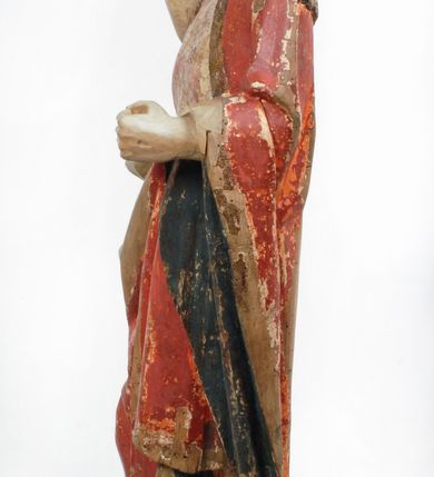 Zdjęcie nr 3: Rzeźba pełnoplastyczna, z tyłu opracowana, drążona wewnątrz, ustawiona na wielobocznej podstawie. Chrystus ukazany frontalnie, w pozycji stojącej, w lekkim kontrapoście, z prawą stopą wysuniętą do przodu, korpus przechylony w lewą stronę, prawy bark podniesiony wyżej od lewego. Prawa ręka wzniesiona ku górze w geście błogosławieństwa, lewa mocno przylega do ciała w okolicy żeber, ugięta w łokciu, w której trzyma drzewce proporca. Twarz pociągła o karnacji cielistej, z zaróżowionymi policzkami, wysokie czoło, szeroko rozstawione, podłużne oczy ze źrenicami i zarysowaną powieką, zaznaczone brwi cienką kreską, długi, prosty nos, wąskie usta. Okala ją zarost oraz długie, gładkie, delikatnie sfalowane włosy, z przedziałkiem, zasłaniające uszy i opadające na kark oraz plecy. W prawym boku i na stopach wyraźne rany. Odziany jest w szatę upiętą pod szyją, w czerwonym kolorze z ciemno- granatową podszewką i złotą lamówką, odsłaniającą tors i wklęsły brzuch, z prawą połą przerzuconą z przodu pod prawą ręką i zawiniętą wokół lewego przedramienia. Fałdy płaszcza są załamane ostro, diagonalnie i nieckowato. Na boku, stopie i lewej ręce zaznaczone rany.