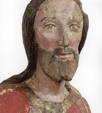 Zdjęcie nr 1: Rzeźba pełnoplastyczna, z tyłu opracowana, drążona wewnątrz, ustawiona na wielobocznej podstawie. Chrystus ukazany frontalnie, w pozycji stojącej, w lekkim kontrapoście, z prawą stopą wysuniętą do przodu, korpus przechylony w lewą stronę, prawy bark podniesiony wyżej od lewego. Prawa ręka wzniesiona ku górze w geście błogosławieństwa, lewa mocno przylega do ciała w okolicy żeber, ugięta w łokciu, w której trzyma drzewce proporca. Twarz pociągła o karnacji cielistej, z zaróżowionymi policzkami, wysokie czoło, szeroko rozstawione, podłużne oczy ze źrenicami i zarysowaną powieką, zaznaczone brwi cienką kreską, długi, prosty nos, wąskie usta. Okala ją zarost oraz długie, gładkie, delikatnie sfalowane włosy, z przedziałkiem, zasłaniające uszy i opadające na kark oraz plecy. W prawym boku i na stopach wyraźne rany. Odziany jest w szatę upiętą pod szyją, w czerwonym kolorze z ciemno- granatową podszewką i złotą lamówką, odsłaniającą tors i wklęsły brzuch, z prawą połą przerzuconą z przodu pod prawą ręką i zawiniętą wokół lewego przedramienia. Fałdy płaszcza są załamane ostro, diagonalnie i nieckowato. Na boku, stopie i lewej ręce zaznaczone rany.