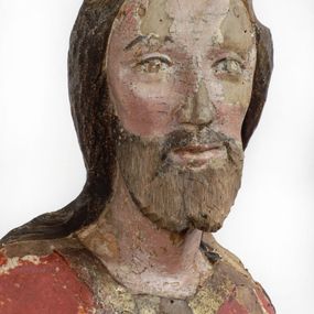 Zdjęcie nr 1: Rzeźba pełnoplastyczna, z tyłu opracowana, drążona wewnątrz, ustawiona na wielobocznej podstawie. Chrystus ukazany frontalnie, w pozycji stojącej, w lekkim kontrapoście, z prawą stopą wysuniętą do przodu, korpus przechylony w lewą stronę, prawy bark podniesiony wyżej od lewego. Prawa ręka wzniesiona ku górze w geście błogosławieństwa, lewa mocno przylega do ciała w okolicy żeber, ugięta w łokciu, w której trzyma drzewce proporca. Twarz pociągła o karnacji cielistej, z zaróżowionymi policzkami, wysokie czoło, szeroko rozstawione, podłużne oczy ze źrenicami i zarysowaną powieką, zaznaczone brwi cienką kreską, długi, prosty nos, wąskie usta. Okala ją zarost oraz długie, gładkie, delikatnie sfalowane włosy, z przedziałkiem, zasłaniające uszy i opadające na kark oraz plecy. W prawym boku i na stopach wyraźne rany. Odziany jest w szatę upiętą pod szyją, w czerwonym kolorze z ciemno- granatową podszewką i złotą lamówką, odsłaniającą tors i wklęsły brzuch, z prawą połą przerzuconą z przodu pod prawą ręką i zawiniętą wokół lewego przedramienia. Fałdy płaszcza są załamane ostro, diagonalnie i nieckowato. Na boku, stopie i lewej ręce zaznaczone rany.