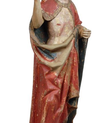 Zdjęcie nr 10: Rzeźba pełnoplastyczna, z tyłu opracowana, drążona wewnątrz, ustawiona na wielobocznej podstawie. Chrystus ukazany frontalnie, w pozycji stojącej, w lekkim kontrapoście, z prawą stopą wysuniętą do przodu, korpus przechylony w lewą stronę, prawy bark podniesiony wyżej od lewego. Prawa ręka wzniesiona ku górze w geście błogosławieństwa, lewa mocno przylega do ciała w okolicy żeber, ugięta w łokciu, w której trzyma drzewce proporca. Twarz pociągła o karnacji cielistej, z zaróżowionymi policzkami, wysokie czoło, szeroko rozstawione, podłużne oczy ze źrenicami i zarysowaną powieką, zaznaczone brwi cienką kreską, długi, prosty nos, wąskie usta. Okala ją zarost oraz długie, gładkie, delikatnie sfalowane włosy, z przedziałkiem, zasłaniające uszy i opadające na kark oraz plecy. W prawym boku i na stopach wyraźne rany. Odziany jest w szatę upiętą pod szyją, w czerwonym kolorze z ciemno- granatową podszewką i złotą lamówką, odsłaniającą tors i wklęsły brzuch, z prawą połą przerzuconą z przodu pod prawą ręką i zawiniętą wokół lewego przedramienia. Fałdy płaszcza są załamane ostro, diagonalnie i nieckowato. Na boku, stopie i lewej ręce zaznaczone rany.