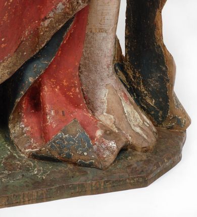 Zdjęcie nr 12: Rzeźba pełnoplastyczna, z tyłu opracowana, drążona wewnątrz, ustawiona na wielobocznej podstawie. Chrystus ukazany frontalnie, w pozycji stojącej, w lekkim kontrapoście, z prawą stopą wysuniętą do przodu, korpus przechylony w lewą stronę, prawy bark podniesiony wyżej od lewego. Prawa ręka wzniesiona ku górze w geście błogosławieństwa, lewa mocno przylega do ciała w okolicy żeber, ugięta w łokciu, w której trzyma drzewce proporca. Twarz pociągła o karnacji cielistej, z zaróżowionymi policzkami, wysokie czoło, szeroko rozstawione, podłużne oczy ze źrenicami i zarysowaną powieką, zaznaczone brwi cienką kreską, długi, prosty nos, wąskie usta. Okala ją zarost oraz długie, gładkie, delikatnie sfalowane włosy, z przedziałkiem, zasłaniające uszy i opadające na kark oraz plecy. W prawym boku i na stopach wyraźne rany. Odziany jest w szatę upiętą pod szyją, w czerwonym kolorze z ciemno- granatową podszewką i złotą lamówką, odsłaniającą tors i wklęsły brzuch, z prawą połą przerzuconą z przodu pod prawą ręką i zawiniętą wokół lewego przedramienia. Fałdy płaszcza są załamane ostro, diagonalnie i nieckowato. Na boku, stopie i lewej ręce zaznaczone rany.