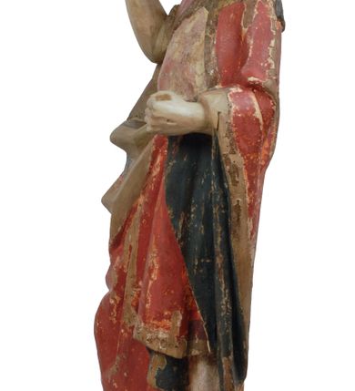 Zdjęcie nr 14: Rzeźba pełnoplastyczna, z tyłu opracowana, drążona wewnątrz, ustawiona na wielobocznej podstawie. Chrystus ukazany frontalnie, w pozycji stojącej, w lekkim kontrapoście, z prawą stopą wysuniętą do przodu, korpus przechylony w lewą stronę, prawy bark podniesiony wyżej od lewego. Prawa ręka wzniesiona ku górze w geście błogosławieństwa, lewa mocno przylega do ciała w okolicy żeber, ugięta w łokciu, w której trzyma drzewce proporca. Twarz pociągła o karnacji cielistej, z zaróżowionymi policzkami, wysokie czoło, szeroko rozstawione, podłużne oczy ze źrenicami i zarysowaną powieką, zaznaczone brwi cienką kreską, długi, prosty nos, wąskie usta. Okala ją zarost oraz długie, gładkie, delikatnie sfalowane włosy, z przedziałkiem, zasłaniające uszy i opadające na kark oraz plecy. W prawym boku i na stopach wyraźne rany. Odziany jest w szatę upiętą pod szyją, w czerwonym kolorze z ciemno- granatową podszewką i złotą lamówką, odsłaniającą tors i wklęsły brzuch, z prawą połą przerzuconą z przodu pod prawą ręką i zawiniętą wokół lewego przedramienia. Fałdy płaszcza są załamane ostro, diagonalnie i nieckowato. Na boku, stopie i lewej ręce zaznaczone rany.