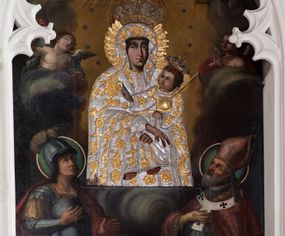 Zdjęcie nr 1: Obraz o kształcie stojącego prostokąta zamkniętego łukiem ostrym. Pośrodku, wśród obłoków przedstawienie Matki Boskiej z Dzieciątkiem na lewym ramieniu, w półpostaci, zwrócona lekko w lewo, z dłońmi skrzyżowanymi w okolicach kolan Chrystusa. Po bokach adorujący dwaj aniołowie Poniżej w narożach kompozycji klęczą po stronie lewej św. Jerzy, po prawej św. Wojciech. Ponad Marią Oko Opatrzności. Matka Boska ubrana jest w czerwoną suknię ze złotą lamówką, na która narzucony ma błękitny płaszcz z kwiatami o żółtych środkach. Głowę wieńczy dekoracyjna korona, podobnie jak Jezusa. Chrystus ukazany jest en trois quarts, w swobodnej pozycji, lewą ręką podtrzymuje  księgę włożoną pod pachę, prawą unosi w geście błogosławieństwa. Ubrany jest w długą sukienkę z długimi rękawami, przewiązaną paskiem, odsłaniającą stopy.  Św. Jerzy, w zbroi i czerwonym płaszczu narzuconym na ramiona, prawą rękę przyłożył do klatki piersiowej, lewą unosi w okolicy tułowia. Na głowie ma hełm z pióropuszem, spod którego widać długie, kręcone włosy opadające na kark. Przy lewym jego boku widoczna jest głowa zabitego smoka. Św. Wojciech, w stroju pontyfikalnym, z paliuszem na ramionach, prawą rękę położył na klatce piersiowej, lewą podtrzymuje połę kapy liturgicznej. Wokół głów świętych koliste nimby. 