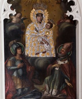 Zdjęcie nr 1: Obraz o kształcie stojącego prostokąta zamkniętego łukiem ostrym. Pośrodku, wśród obłoków przedstawienie Matki Boskiej z Dzieciątkiem na lewym ramieniu, w półpostaci, zwrócona lekko w lewo, z dłońmi skrzyżowanymi w okolicach kolan Chrystusa. Po bokach adorujący dwaj aniołowie Poniżej w narożach kompozycji klęczą po stronie lewej św. Jerzy, po prawej św. Wojciech. Ponad Marią Oko Opatrzności. Matka Boska ubrana jest w czerwoną suknię ze złotą lamówką, na która narzucony ma błękitny płaszcz z kwiatami o żółtych środkach. Głowę wieńczy dekoracyjna korona, podobnie jak Jezusa. Chrystus ukazany jest en trois quarts, w swobodnej pozycji, lewą ręką podtrzymuje  księgę włożoną pod pachę, prawą unosi w geście błogosławieństwa. Ubrany jest w długą sukienkę z długimi rękawami, przewiązaną paskiem, odsłaniającą stopy.  Św. Jerzy, w zbroi i czerwonym płaszczu narzuconym na ramiona, prawą rękę przyłożył do klatki piersiowej, lewą unosi w okolicy tułowia. Na głowie ma hełm z pióropuszem, spod którego widać długie, kręcone włosy opadające na kark. Przy lewym jego boku widoczna jest głowa zabitego smoka. Św. Wojciech, w stroju pontyfikalnym, z paliuszem na ramionach, prawą rękę położył na klatce piersiowej, lewą podtrzymuje połę kapy liturgicznej. Wokół głów świętych koliste nimby. 