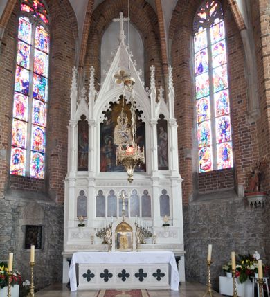 Zdjęcie nr 1: Neogotycki ołtarz główny w kolorze naturalnego wapienia, architektoniczny, wolnostojący, trójosiowy, z wydzieloną częścią cokołową, dwukondygnacyjny, ze zwieńczeniem. Mensa skrzyniowa, ujęta dwiema kolumienkami. Antependium ozdobione płycinami w kształcie czworoliści. Nastawa artykułowana w dolnej kondygnacji czworobocznymi półfilarami, w górnej kondygnacji kolumienkami o liściastych kapitelach, z opaskami w połowie wysokości, przechodzącymi w zwieńczeniu w pinakle. Dolna kondygnacja dwustrefowa. W strefie dolnej stylizowana wić roślinna i tarcze herbowe. W strefie górnej nisze zamknięte trójlistnie (na relikwiarze?), w osi środkowej pięć, w osiach skrajnych po jednej. W kondygnacji górnej nisze, środkowa szeroka, zamknięta ostrołukowo z maswerkowaniem w podłuczu, w osiach skrajnych wąskie, zamknięte trójlistnie. W niszy środkowej obraz Adoracja Matki Boskiej Śnieżnej przez śś. Wojciecha i Jerzego, po bokach obrazy: po prawej Św. Florian, z sygnaturą w dolnej części -  S. Bryniarski / pinxit 1886; po lewej postać kobiety w prawej ręce ze zwojem z napisem: EWAN/GELJA, z sygnaturą u dołu - S. Bryniarski / malował. W zwieńczeniu pomiędzy pinaklami trójkątne szczyty z żabkami na krawędziach, środkowy w polu z rozetą z Gołębicą Ducha Świętego na złotym tle, zakończony krzyżem. 