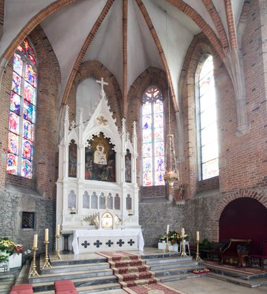 Zdjęcie nr 30: Neogotycki ołtarz główny w kolorze naturalnego wapienia, architektoniczny, wolnostojący, trójosiowy, z wydzieloną częścią cokołową, dwukondygnacyjny, ze zwieńczeniem. Mensa skrzyniowa, ujęta dwiema kolumienkami. Antependium ozdobione płycinami w kształcie czworoliści. Nastawa artykułowana w dolnej kondygnacji czworobocznymi półfilarami, w górnej kondygnacji kolumienkami o liściastych kapitelach, z opaskami w połowie wysokości, przechodzącymi w zwieńczeniu w pinakle. Dolna kondygnacja dwustrefowa. W strefie dolnej stylizowana wić roślinna i tarcze herbowe. W strefie górnej nisze zamknięte trójlistnie (na relikwiarze?), w osi środkowej pięć, w osiach skrajnych po jednej. W kondygnacji górnej nisze, środkowa szeroka, zamknięta ostrołukowo z maswerkowaniem w podłuczu, w osiach skrajnych wąskie, zamknięte trójlistnie. W niszy środkowej obraz Adoracja Matki Boskiej Śnieżnej przez śś. Wojciecha i Jerzego, po bokach obrazy: po prawej Św. Florian, z sygnaturą w dolnej części -  S. Bryniarski / pinxit 1886; po lewej postać kobiety w prawej ręce ze zwojem z napisem: EWAN/GELJA, z sygnaturą u dołu - S. Bryniarski / malował. W zwieńczeniu pomiędzy pinaklami trójkątne szczyty z żabkami na krawędziach, środkowy w polu z rozetą z Gołębicą Ducha Świętego na złotym tle, zakończony krzyżem. 