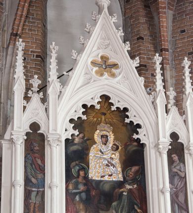 Zdjęcie nr 8: Neogotycki ołtarz główny w kolorze naturalnego wapienia, architektoniczny, wolnostojący, trójosiowy, z wydzieloną częścią cokołową, dwukondygnacyjny, ze zwieńczeniem. Mensa skrzyniowa, ujęta dwiema kolumienkami. Antependium ozdobione płycinami w kształcie czworoliści. Nastawa artykułowana w dolnej kondygnacji czworobocznymi półfilarami, w górnej kondygnacji kolumienkami o liściastych kapitelach, z opaskami w połowie wysokości, przechodzącymi w zwieńczeniu w pinakle. Dolna kondygnacja dwustrefowa. W strefie dolnej stylizowana wić roślinna i tarcze herbowe. W strefie górnej nisze zamknięte trójlistnie (na relikwiarze?), w osi środkowej pięć, w osiach skrajnych po jednej. W kondygnacji górnej nisze, środkowa szeroka, zamknięta ostrołukowo z maswerkowaniem w podłuczu, w osiach skrajnych wąskie, zamknięte trójlistnie. W niszy środkowej obraz Adoracja Matki Boskiej Śnieżnej przez śś. Wojciecha i Jerzego, po bokach obrazy: po prawej Św. Florian, z sygnaturą w dolnej części -  S. Bryniarski / pinxit 1886; po lewej postać kobiety w prawej ręce ze zwojem z napisem: EWAN/GELJA, z sygnaturą u dołu - S. Bryniarski / malował. W zwieńczeniu pomiędzy pinaklami trójkątne szczyty z żabkami na krawędziach, środkowy w polu z rozetą z Gołębicą Ducha Świętego na złotym tle, zakończony krzyżem. 
