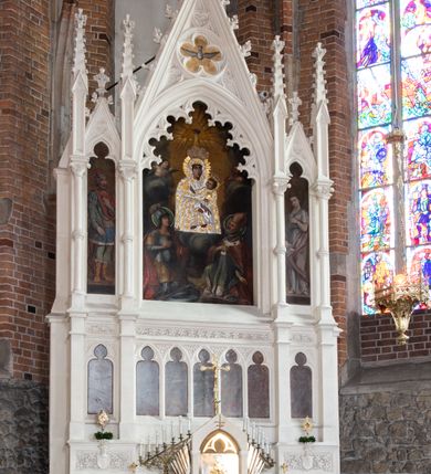 Zdjęcie nr 26: Neogotycki ołtarz główny w kolorze naturalnego wapienia, architektoniczny, wolnostojący, trójosiowy, z wydzieloną częścią cokołową, dwukondygnacyjny, ze zwieńczeniem. Mensa skrzyniowa, ujęta dwiema kolumienkami. Antependium ozdobione płycinami w kształcie czworoliści. Nastawa artykułowana w dolnej kondygnacji czworobocznymi półfilarami, w górnej kondygnacji kolumienkami o liściastych kapitelach, z opaskami w połowie wysokości, przechodzącymi w zwieńczeniu w pinakle. Dolna kondygnacja dwustrefowa. W strefie dolnej stylizowana wić roślinna i tarcze herbowe. W strefie górnej nisze zamknięte trójlistnie (na relikwiarze?), w osi środkowej pięć, w osiach skrajnych po jednej. W kondygnacji górnej nisze, środkowa szeroka, zamknięta ostrołukowo z maswerkowaniem w podłuczu, w osiach skrajnych wąskie, zamknięte trójlistnie. W niszy środkowej obraz Adoracja Matki Boskiej Śnieżnej przez śś. Wojciecha i Jerzego, po bokach obrazy: po prawej Św. Florian, z sygnaturą w dolnej części -  S. Bryniarski / pinxit 1886; po lewej postać kobiety w prawej ręce ze zwojem z napisem: EWAN/GELJA, z sygnaturą u dołu - S. Bryniarski / malował. W zwieńczeniu pomiędzy pinaklami trójkątne szczyty z żabkami na krawędziach, środkowy w polu z rozetą z Gołębicą Ducha Świętego na złotym tle, zakończony krzyżem. 