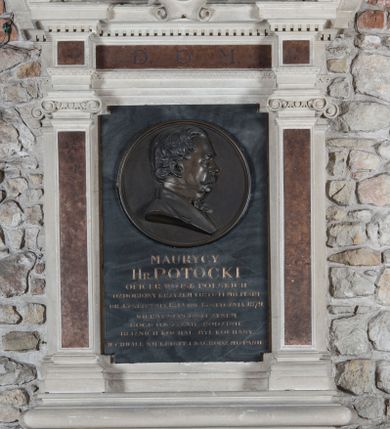 Zdjęcie nr 1: Epitafium w formie kamiennej tablicy, w kształcie stojącego prostokąta, flankowanej po bokach zdwojonymi pilastrami o jońskich kapitelach, posadowionymi na szerokim, profilowanym gzymsie z podwieszonymi ulistnionymi wolutami, dźwigającymi przełamane belkowanie, z wydatnym gzymsem, zwieńczone przyczółkiem w kształcie łuku odcinkowego. Na przyczółku cokolik ujęty wolutkami i krzyż o rozszerzających się ramionach, zaś w polu kartusz z godłem herbu Pilawa. Pośrodku epitafium okrągły medalion z popiersiem zmarłego, ukazanym z prawego profilu, w marynarce z muszką. Jego twarz jest pełna, nos krótki, wydatny, włosy kręcone, a twarz zdobią długie, sumiaste wąsy. W fryzie belkowania inskrypcja „D(EO) O(PTIMO) M(AXIMO)”, a poniżej medalionu jej kontynuacja „MAURYCY / HR(ABIA) POTOCKI / OFICER WOJSK POLSKICH / OZDOBIONY KRZYŻEM VIRTUTI MILITARI / UR(ODZONY) 13 STYCZNIA 1812 UM(ARŁY) 13 STYCZNIA 1879. / WIERNY SERCEM I CZYNEM / BOGU, OJCZYŹNIE, RODZINIE / BLIŹNICH KOCHAŁ – BYŁ KOCHANY / W CHWALE WIEKUISTEJ NAGRÓDŹ MU PANIE!” Na popiersiu sygnatura „MODELOWAŁA NATALIA POTOCKA”. Druga sygnatura na cokole, w prawym, dolnym rogu „E(DWARD) STEHLIK W KRAKOWIE”. 