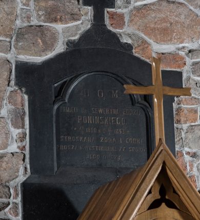 Zdjęcie nr 2: W kształcie aedikuli, z wydzielonym cokołem, ujęte lizenami i zwieńczone gzymsem i uskokowym szczytem z krzyżem łacińskim pośrodku. W polu środkowym płycina prostokątna zamknięta trójlistnie z inskrypcją majuskułową, po polsku: D. O. M. / PAMIĘCI SEWERYNA ŁODZIA / PONIŃSKIEGO / UR. 1810 r. ZM. 1853 r. / STROSKANE ŻONA I CÓRKA / PROSZĄ O WESTCHNIENIE ZA SPOKÓJ /JEGO DUSZY.