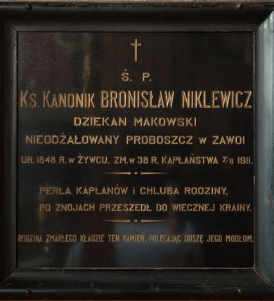 Zdjęcie nr 1: Płyta kamienna w formie kwadratu, ujęta drewnianą, profilowaną ramą, pomalowaną na czarno. W polu złocona inskrypcja: „Ś(więtej) P(amięci) / Ks(iądz) KANONIK BRONISŁAW NIKLEWICZ / DZIEKAN MAKOWSKI / NIEODŻAŁOWANY PROBOSZCZ w ZAWOI / UR(ODZONY) 1848 R(OKU) w ŻYWCU, ZM(ARŁ) w 38 R(OKU) KAPŁAŃSTWA 7/8 1911. / PERŁA KAPŁANÓW I CHLUBA RODZINY, / PO ZNOJACH PRZESZEDŁ DO WIECZNEJ KRAINY. / RODZINA ZMARŁEGO KŁADZIE TEN KAMIEŃ, POLECAJĄC DUSZĘ JEGO MODŁOM.” Nad inskrypcją krzyż łaciński.