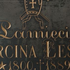 Zdjęcie nr 1: Płyta kamienna w formie kwadratu ujęta drewnianą, profilowaną ramą, polichromowaną na czarno. W polu złocona inskrypcja: „Pamięci / KS(IĘDZA) MARCINA LEŚNIAKA / *1800. +1889. / PREPOZYTA INFUŁATA KAPITUŁY TARNOWSKIEJ / poprzednio zaś / od 1836 do 1856 / PIERWSZEGO PROBOSZCZA TEJ PARAFII / dobrodzieja kościoła i szkoły tutejszej / dobrego pasterza perły między kapłanami / którego Imie niech będzie błogosławione / poświęcają tę tablice / wdzięczni parafianie. / R(equiescat) I(n) P(ace)”. Inicjały imienia i nazwiska zdobione wolutami. Nad inskrypcją ryte przedstawienie infuły z taśmami (fannones), ze skrzyżowanym pastorałem i krzyżem.