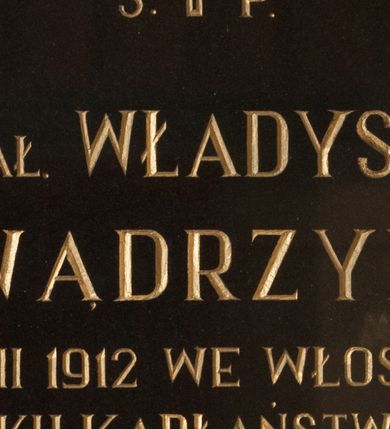 Zdjęcie nr 1: Płyta granitowa w formie prostokąta zbliżonego do kwadratu, w drewnianej, profilowanej ramie, polichromowanej na czarno. W polu złocona inskrypcją: „Ś(więtej) P(amięci) / KS(IĄDZ) PRAŁ(AT) WŁADYSŁAW / WĄDRZYK / UR(ODZONY) 11 VIII 1912 WE WŁOSIENICY / ZM(ARŁ) W 51 ROKU KAPŁAŃSTWA 13 XI 1990 / WICEDZIEKAN DEKANATU MAKOWSKIEGO / PROBOSZCZ W ZAWOI W LAT(ACH) 1957 – 1987 / GORLIWY I ODDANY APOSTOŁ SŁOWA / BOŻEGO. / Na wieczną pamiątkę Bogu wdzięczni / za okazaną miłość i dobroć / Parafianie.”