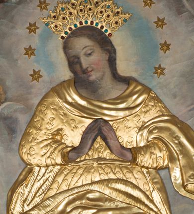 Zdjęcie nr 1: Obraz w formie stojącego prostokąta zamkniętego łukiem półkolistym. W centrum Maria ukazana w całej postaci, stoi na sierpie księżyca i globie, na którym wije się wąż. Przedstawiona jest frontalnie, w kontrapoście, z pochyloną głową skierowaną w prawo oraz dłońmi złożonymi w geście modlitwy. Twarz ma owalną, o migdałowatych, półprzymkniętych oczach, prostym nosie i małych ustach, okoloną długimi włosami, opadającymi na plecy. Ciało zakrywa metalowa, złocona sukienka, w postaci sukni, dekorowanej motywem kwiatowym, przepasanej w talii oraz płaszcz zawieszony na lewym przedramieniu i rozwiany z przodu, w partii nóg. Na głowie aplikowana, złocona, kameryzowana korona otwarta, a wokół niej wieniec z 12 aplikowanych gwiazd. Matka Boska ukazana jest na tle gęstych obłoków; w górnej części obrazu cztery grupy uskrzydlonych główek anielskich. 