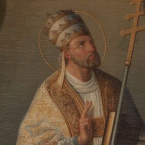Zdjęcie nr 1: Obraz w formie stojącego prostokąta. W centrum św. Klemens ukazany w całej postaci, zwrócony w trzech czwartych w lewo, z uniesioną głową. Lewą ręką przytrzymuje księgę oraz ferulę, prawą unosi w geście błogosławieństwa. Twarz ma pociągłą, o dużych oczach zwróconych w górę, dużym nosie i pełnych ustach; okoloną krótką, siwą brodą oraz krótkimi, kręconymi włosami. Na głowie ma tiarę papieską z taśmami (fannones), wokół niej nimb. Święty ubrany jest w niebieską albę, białą rokietę lamowaną koronką, żółtą stułę oraz jasnożółtą kapę o wzorze roślinnym, z dekoracyjną bordiurą. Obok świętego leży kotwica. Postać ukazana na tle pejzażu z morzem i statkiem, ze sceną męczeństwa świętego.


