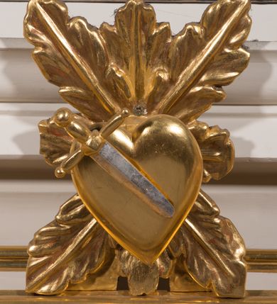 Zdjęcie nr 20: Nastawa architektoniczna, jednokondygnacyjna ze zwieńczeniem, ustawiona na dwustrefowym cokole, w górnej strefie z wyłamanymi, zdwojonymi prostopadłościanami. Ołtarz drewniany, prostopadłościenny, z drewnianą mensą. Antepedium ujęte profilowaną ramą, w polu na pomarańczowym tle namalowana korona otwarta z różańcem nad symetrycznie umieszczonymi liśćmi, z napisem „Królowo różańca świętego módl się za nami”. Nastawa ujęta parą kolumn o skręconych trzonach podzielonych na dwie strefy i kapitelach kompozytowych, ustawionych na tle wyłamanych ścianek bocznych nastawy. Podpory dźwigają pełne belkowanie, częściowo przerwane nad polem środkowym, wyłamane na ich osi. Na belkowaniu ustawione figury aniołów z arma Christi. Pole centralne wypełnione wnęką w formie stojącego prostokąta o ściętych górnych narożach, ujęte profilowaną ramą, z płaskorzeźbą Matki Boskiej Różańcowej. Wnęka flankowana ornamentem roślinnym, w przyłuczach dwa putta. Kondygnacja ujęta uszami utworzonymi z akantu i wstęgi. Zwieńczenie w formie leżącego prostokąta. W polu obraz Chrystusa w Ogrójcu o kształcie zbliżonym do kwadratu, ujęty profilowaną ramą. Obraz flankują figury św. Marii Magdaleny i św. Weroniki, nad którymi znajdują się baldachimy ze stylizowanym lambrekinem. Całość zwieńczona płaskorzeźbą tronującego Boga Ojca pośród obłoków i uskrzydlonych główek anielskich, w glorii promienistej. Struktura polichromowana w kolorze białym, profile złocone, kolumny, ornamentyka złocone i srebrzone. 


