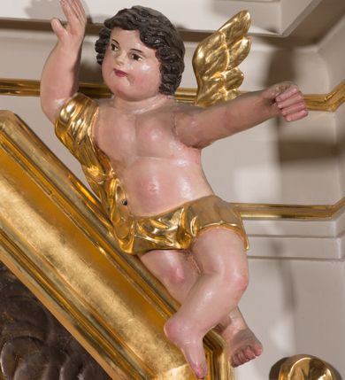 Zdjęcie nr 21: Nastawa architektoniczna, jednokondygnacyjna ze zwieńczeniem, ustawiona na dwustrefowym cokole, w górnej strefie z wyłamanymi, zdwojonymi prostopadłościanami. Ołtarz drewniany, prostopadłościenny, z drewnianą mensą. Antepedium ujęte profilowaną ramą, w polu na pomarańczowym tle namalowana korona otwarta z różańcem nad symetrycznie umieszczonymi liśćmi, z napisem „Królowo różańca świętego módl się za nami”. Nastawa ujęta parą kolumn o skręconych trzonach podzielonych na dwie strefy i kapitelach kompozytowych, ustawionych na tle wyłamanych ścianek bocznych nastawy. Podpory dźwigają pełne belkowanie, częściowo przerwane nad polem środkowym, wyłamane na ich osi. Na belkowaniu ustawione figury aniołów z arma Christi. Pole centralne wypełnione wnęką w formie stojącego prostokąta o ściętych górnych narożach, ujęte profilowaną ramą, z płaskorzeźbą Matki Boskiej Różańcowej. Wnęka flankowana ornamentem roślinnym, w przyłuczach dwa putta. Kondygnacja ujęta uszami utworzonymi z akantu i wstęgi. Zwieńczenie w formie leżącego prostokąta. W polu obraz Chrystusa w Ogrójcu o kształcie zbliżonym do kwadratu, ujęty profilowaną ramą. Obraz flankują figury św. Marii Magdaleny i św. Weroniki, nad którymi znajdują się baldachimy ze stylizowanym lambrekinem. Całość zwieńczona płaskorzeźbą tronującego Boga Ojca pośród obłoków i uskrzydlonych główek anielskich, w glorii promienistej. Struktura polichromowana w kolorze białym, profile złocone, kolumny, ornamentyka złocone i srebrzone. 


