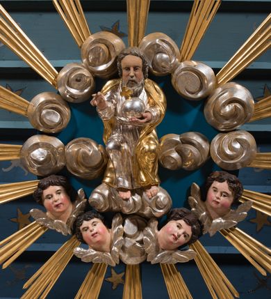 Zdjęcie nr 23: Nastawa architektoniczna, jednokondygnacyjna ze zwieńczeniem, ustawiona na dwustrefowym cokole, w górnej strefie z wyłamanymi, zdwojonymi prostopadłościanami. Ołtarz drewniany, prostopadłościenny, z drewnianą mensą. Antepedium ujęte profilowaną ramą, w polu na pomarańczowym tle namalowana korona otwarta z różańcem nad symetrycznie umieszczonymi liśćmi, z napisem „Królowo różańca świętego módl się za nami”. Nastawa ujęta parą kolumn o skręconych trzonach podzielonych na dwie strefy i kapitelach kompozytowych, ustawionych na tle wyłamanych ścianek bocznych nastawy. Podpory dźwigają pełne belkowanie, częściowo przerwane nad polem środkowym, wyłamane na ich osi. Na belkowaniu ustawione figury aniołów z arma Christi. Pole centralne wypełnione wnęką w formie stojącego prostokąta o ściętych górnych narożach, ujęte profilowaną ramą, z płaskorzeźbą Matki Boskiej Różańcowej. Wnęka flankowana ornamentem roślinnym, w przyłuczach dwa putta. Kondygnacja ujęta uszami utworzonymi z akantu i wstęgi. Zwieńczenie w formie leżącego prostokąta. W polu obraz Chrystusa w Ogrójcu o kształcie zbliżonym do kwadratu, ujęty profilowaną ramą. Obraz flankują figury św. Marii Magdaleny i św. Weroniki, nad którymi znajdują się baldachimy ze stylizowanym lambrekinem. Całość zwieńczona płaskorzeźbą tronującego Boga Ojca pośród obłoków i uskrzydlonych główek anielskich, w glorii promienistej. Struktura polichromowana w kolorze białym, profile złocone, kolumny, ornamentyka złocone i srebrzone. 


