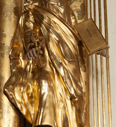 Zdjęcie nr 26: Nastawa architektoniczna, jednokondygnacyjna ze zwieńczeniem, jednoosiowa z bramkami, ustawiona na dwustrefowym cokole, z wyłamanymi pod kątem dwiema parami prostopadłościanów w górnej strefie. Ołtarz kamienny, prostopadłościenny, w drewnianej obudowie, z drewnianą mensą. Antepedium ujęte profilowaną ramą, w centrum medalion z krzyżem o trójlistnym zakończeniu ramion i promieniami na ich skrzyżowaniu, po bokach monogramy maryjny i IHS. Na ołtarzu tabernakulum z tronem wystawienia. Nastawa ujęta dwiema parami kolumn, przedzielonych dwiema parami filarów o kanelowanych trzonach, ustawionych pod kątem. Podpory dźwigają pełne belkowanie, wyłamane pod kątem na ich osi, przerwane nad polem środkowym oraz fragmenty przerwanego, półkolistego przyczółka z siedzącymi na nich puttami. Pomiędzy kolumnami ustawione figury św. Piotra i św. Pawła. W polu środkowym wnęka z obrazem św. Klemensa w formie stojącego prostokąta zakończona łukiem segmentowym z uskokiem, ujęta profilowaną ramą zwieńczoną dwiema zwróconymi ku sobie wolutami, podtrzymującymi koronę otwartą, flankowaną przez dwa putta. Kondygnacja ujęta uszami utworzonymi z suchego akantu i wstęgi. Zwieńczenie o kształcie zbliżonym do leżącego prostokąta, zamkniętego fragmentem segmentowo wyłamanego gzymsu, flankowanego spływami wolutowymi. Całe pole wypełnia obraz Zwiastowania, ujęty liśćmi. Zwieńczenie zakończone płaskorzeźbionym przedstawieniem Trójcy Świętej pośród obłoków i uskrzydlonych główek anielskich, w glorii promienistej. Bramki flankowane pilastrami o kanelowanych trzonach, podtrzymującymi nadproże wyłamane na kształt łuku kotarowego, zwieńczone kluczami z puttami. Na osi pilastrów ustawione po dwa wazony. Przejścia w formie stojącego prostokąta zamkniętego łukiem segmentowym nadwieszonym. Struktura polichromowana w kolorze białym; kolumny, profile i ornamentyka złocone, detal srebrzony. Z tyłu ołtarza ryta inskrypcja: „I.L.O.Z / 9/5 1845”.