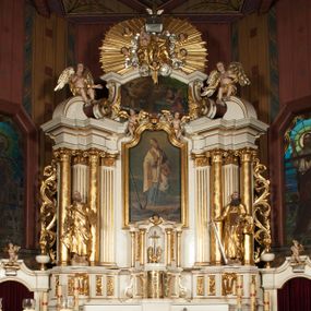 Zdjęcie nr 1: Nastawa architektoniczna, jednokondygnacyjna ze zwieńczeniem, jednoosiowa z bramkami, ustawiona na dwustrefowym cokole, z wyłamanymi pod kątem dwiema parami prostopadłościanów w górnej strefie. Ołtarz kamienny, prostopadłościenny, w drewnianej obudowie, z drewnianą mensą. Antepedium ujęte profilowaną ramą, w centrum medalion z krzyżem o trójlistnym zakończeniu ramion i promieniami na ich skrzyżowaniu, po bokach monogramy maryjny i IHS. Na ołtarzu tabernakulum z tronem wystawienia. Nastawa ujęta dwiema parami kolumn, przedzielonych dwiema parami filarów o kanelowanych trzonach, ustawionych pod kątem. Podpory dźwigają pełne belkowanie, wyłamane pod kątem na ich osi, przerwane nad polem środkowym oraz fragmenty przerwanego, półkolistego przyczółka z siedzącymi na nich puttami. Pomiędzy kolumnami ustawione figury św. Piotra i św. Pawła. W polu środkowym wnęka z obrazem św. Klemensa w formie stojącego prostokąta zakończona łukiem segmentowym z uskokiem, ujęta profilowaną ramą zwieńczoną dwiema zwróconymi ku sobie wolutami, podtrzymującymi koronę otwartą, flankowaną przez dwa putta. Kondygnacja ujęta uszami utworzonymi z suchego akantu i wstęgi. Zwieńczenie o kształcie zbliżonym do leżącego prostokąta, zamkniętego fragmentem segmentowo wyłamanego gzymsu, flankowanego spływami wolutowymi. Całe pole wypełnia obraz Zwiastowania, ujęty liśćmi. Zwieńczenie zakończone płaskorzeźbionym przedstawieniem Trójcy Świętej pośród obłoków i uskrzydlonych główek anielskich, w glorii promienistej. Bramki flankowane pilastrami o kanelowanych trzonach, podtrzymującymi nadproże wyłamane na kształt łuku kotarowego, zwieńczone kluczami z puttami. Na osi pilastrów ustawione po dwa wazony. Przejścia w formie stojącego prostokąta zamkniętego łukiem segmentowym nadwieszonym. Struktura polichromowana w kolorze białym; kolumny, profile i ornamentyka złocone, detal srebrzony. Z tyłu ołtarza ryta inskrypcja: „I.L.O.Z / 9/5 1845”.