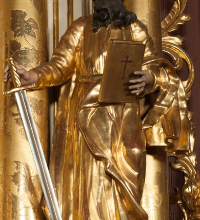 Zdjęcie nr 23: Nastawa architektoniczna, jednokondygnacyjna ze zwieńczeniem, jednoosiowa z bramkami, ustawiona na dwustrefowym cokole, z wyłamanymi pod kątem dwiema parami prostopadłościanów w górnej strefie. Ołtarz kamienny, prostopadłościenny, w drewnianej obudowie, z drewnianą mensą. Antepedium ujęte profilowaną ramą, w centrum medalion z krzyżem o trójlistnym zakończeniu ramion i promieniami na ich skrzyżowaniu, po bokach monogramy maryjny i IHS. Na ołtarzu tabernakulum z tronem wystawienia. Nastawa ujęta dwiema parami kolumn, przedzielonych dwiema parami filarów o kanelowanych trzonach, ustawionych pod kątem. Podpory dźwigają pełne belkowanie, wyłamane pod kątem na ich osi, przerwane nad polem środkowym oraz fragmenty przerwanego, półkolistego przyczółka z siedzącymi na nich puttami. Pomiędzy kolumnami ustawione figury św. Piotra i św. Pawła. W polu środkowym wnęka z obrazem św. Klemensa w formie stojącego prostokąta zakończona łukiem segmentowym z uskokiem, ujęta profilowaną ramą zwieńczoną dwiema zwróconymi ku sobie wolutami, podtrzymującymi koronę otwartą, flankowaną przez dwa putta. Kondygnacja ujęta uszami utworzonymi z suchego akantu i wstęgi. Zwieńczenie o kształcie zbliżonym do leżącego prostokąta, zamkniętego fragmentem segmentowo wyłamanego gzymsu, flankowanego spływami wolutowymi. Całe pole wypełnia obraz Zwiastowania, ujęty liśćmi. Zwieńczenie zakończone płaskorzeźbionym przedstawieniem Trójcy Świętej pośród obłoków i uskrzydlonych główek anielskich, w glorii promienistej. Bramki flankowane pilastrami o kanelowanych trzonach, podtrzymującymi nadproże wyłamane na kształt łuku kotarowego, zwieńczone kluczami z puttami. Na osi pilastrów ustawione po dwa wazony. Przejścia w formie stojącego prostokąta zamkniętego łukiem segmentowym nadwieszonym. Struktura polichromowana w kolorze białym; kolumny, profile i ornamentyka złocone, detal srebrzony. Z tyłu ołtarza ryta inskrypcja: „I.L.O.Z / 9/5 1845”.