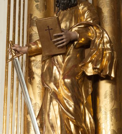 Zdjęcie nr 24: Nastawa architektoniczna, jednokondygnacyjna ze zwieńczeniem, jednoosiowa z bramkami, ustawiona na dwustrefowym cokole, z wyłamanymi pod kątem dwiema parami prostopadłościanów w górnej strefie. Ołtarz kamienny, prostopadłościenny, w drewnianej obudowie, z drewnianą mensą. Antepedium ujęte profilowaną ramą, w centrum medalion z krzyżem o trójlistnym zakończeniu ramion i promieniami na ich skrzyżowaniu, po bokach monogramy maryjny i IHS. Na ołtarzu tabernakulum z tronem wystawienia. Nastawa ujęta dwiema parami kolumn, przedzielonych dwiema parami filarów o kanelowanych trzonach, ustawionych pod kątem. Podpory dźwigają pełne belkowanie, wyłamane pod kątem na ich osi, przerwane nad polem środkowym oraz fragmenty przerwanego, półkolistego przyczółka z siedzącymi na nich puttami. Pomiędzy kolumnami ustawione figury św. Piotra i św. Pawła. W polu środkowym wnęka z obrazem św. Klemensa w formie stojącego prostokąta zakończona łukiem segmentowym z uskokiem, ujęta profilowaną ramą zwieńczoną dwiema zwróconymi ku sobie wolutami, podtrzymującymi koronę otwartą, flankowaną przez dwa putta. Kondygnacja ujęta uszami utworzonymi z suchego akantu i wstęgi. Zwieńczenie o kształcie zbliżonym do leżącego prostokąta, zamkniętego fragmentem segmentowo wyłamanego gzymsu, flankowanego spływami wolutowymi. Całe pole wypełnia obraz Zwiastowania, ujęty liśćmi. Zwieńczenie zakończone płaskorzeźbionym przedstawieniem Trójcy Świętej pośród obłoków i uskrzydlonych główek anielskich, w glorii promienistej. Bramki flankowane pilastrami o kanelowanych trzonach, podtrzymującymi nadproże wyłamane na kształt łuku kotarowego, zwieńczone kluczami z puttami. Na osi pilastrów ustawione po dwa wazony. Przejścia w formie stojącego prostokąta zamkniętego łukiem segmentowym nadwieszonym. Struktura polichromowana w kolorze białym; kolumny, profile i ornamentyka złocone, detal srebrzony. Z tyłu ołtarza ryta inskrypcja: „I.L.O.Z / 9/5 1845”.