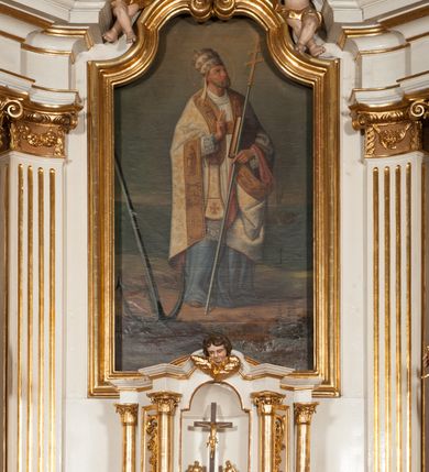 Zdjęcie nr 5: Nastawa architektoniczna, jednokondygnacyjna ze zwieńczeniem, jednoosiowa z bramkami, ustawiona na dwustrefowym cokole, z wyłamanymi pod kątem dwiema parami prostopadłościanów w górnej strefie. Ołtarz kamienny, prostopadłościenny, w drewnianej obudowie, z drewnianą mensą. Antepedium ujęte profilowaną ramą, w centrum medalion z krzyżem o trójlistnym zakończeniu ramion i promieniami na ich skrzyżowaniu, po bokach monogramy maryjny i IHS. Na ołtarzu tabernakulum z tronem wystawienia. Nastawa ujęta dwiema parami kolumn, przedzielonych dwiema parami filarów o kanelowanych trzonach, ustawionych pod kątem. Podpory dźwigają pełne belkowanie, wyłamane pod kątem na ich osi, przerwane nad polem środkowym oraz fragmenty przerwanego, półkolistego przyczółka z siedzącymi na nich puttami. Pomiędzy kolumnami ustawione figury św. Piotra i św. Pawła. W polu środkowym wnęka z obrazem św. Klemensa w formie stojącego prostokąta zakończona łukiem segmentowym z uskokiem, ujęta profilowaną ramą zwieńczoną dwiema zwróconymi ku sobie wolutami, podtrzymującymi koronę otwartą, flankowaną przez dwa putta. Kondygnacja ujęta uszami utworzonymi z suchego akantu i wstęgi. Zwieńczenie o kształcie zbliżonym do leżącego prostokąta, zamkniętego fragmentem segmentowo wyłamanego gzymsu, flankowanego spływami wolutowymi. Całe pole wypełnia obraz Zwiastowania, ujęty liśćmi. Zwieńczenie zakończone płaskorzeźbionym przedstawieniem Trójcy Świętej pośród obłoków i uskrzydlonych główek anielskich, w glorii promienistej. Bramki flankowane pilastrami o kanelowanych trzonach, podtrzymującymi nadproże wyłamane na kształt łuku kotarowego, zwieńczone kluczami z puttami. Na osi pilastrów ustawione po dwa wazony. Przejścia w formie stojącego prostokąta zamkniętego łukiem segmentowym nadwieszonym. Struktura polichromowana w kolorze białym; kolumny, profile i ornamentyka złocone, detal srebrzony. Z tyłu ołtarza ryta inskrypcja: „I.L.O.Z / 9/5 1845”.