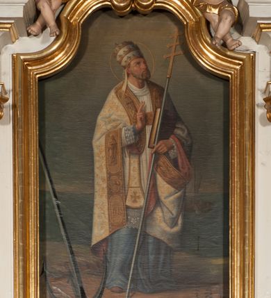 Zdjęcie nr 6: Nastawa architektoniczna, jednokondygnacyjna ze zwieńczeniem, jednoosiowa z bramkami, ustawiona na dwustrefowym cokole, z wyłamanymi pod kątem dwiema parami prostopadłościanów w górnej strefie. Ołtarz kamienny, prostopadłościenny, w drewnianej obudowie, z drewnianą mensą. Antepedium ujęte profilowaną ramą, w centrum medalion z krzyżem o trójlistnym zakończeniu ramion i promieniami na ich skrzyżowaniu, po bokach monogramy maryjny i IHS. Na ołtarzu tabernakulum z tronem wystawienia. Nastawa ujęta dwiema parami kolumn, przedzielonych dwiema parami filarów o kanelowanych trzonach, ustawionych pod kątem. Podpory dźwigają pełne belkowanie, wyłamane pod kątem na ich osi, przerwane nad polem środkowym oraz fragmenty przerwanego, półkolistego przyczółka z siedzącymi na nich puttami. Pomiędzy kolumnami ustawione figury św. Piotra i św. Pawła. W polu środkowym wnęka z obrazem św. Klemensa w formie stojącego prostokąta zakończona łukiem segmentowym z uskokiem, ujęta profilowaną ramą zwieńczoną dwiema zwróconymi ku sobie wolutami, podtrzymującymi koronę otwartą, flankowaną przez dwa putta. Kondygnacja ujęta uszami utworzonymi z suchego akantu i wstęgi. Zwieńczenie o kształcie zbliżonym do leżącego prostokąta, zamkniętego fragmentem segmentowo wyłamanego gzymsu, flankowanego spływami wolutowymi. Całe pole wypełnia obraz Zwiastowania, ujęty liśćmi. Zwieńczenie zakończone płaskorzeźbionym przedstawieniem Trójcy Świętej pośród obłoków i uskrzydlonych główek anielskich, w glorii promienistej. Bramki flankowane pilastrami o kanelowanych trzonach, podtrzymującymi nadproże wyłamane na kształt łuku kotarowego, zwieńczone kluczami z puttami. Na osi pilastrów ustawione po dwa wazony. Przejścia w formie stojącego prostokąta zamkniętego łukiem segmentowym nadwieszonym. Struktura polichromowana w kolorze białym; kolumny, profile i ornamentyka złocone, detal srebrzony. Z tyłu ołtarza ryta inskrypcja: „I.L.O.Z / 9/5 1845”.