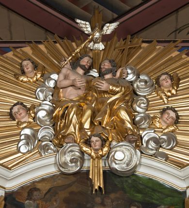Zdjęcie nr 15: Nastawa architektoniczna, jednokondygnacyjna ze zwieńczeniem, jednoosiowa z bramkami, ustawiona na dwustrefowym cokole, z wyłamanymi pod kątem dwiema parami prostopadłościanów w górnej strefie. Ołtarz kamienny, prostopadłościenny, w drewnianej obudowie, z drewnianą mensą. Antepedium ujęte profilowaną ramą, w centrum medalion z krzyżem o trójlistnym zakończeniu ramion i promieniami na ich skrzyżowaniu, po bokach monogramy maryjny i IHS. Na ołtarzu tabernakulum z tronem wystawienia. Nastawa ujęta dwiema parami kolumn, przedzielonych dwiema parami filarów o kanelowanych trzonach, ustawionych pod kątem. Podpory dźwigają pełne belkowanie, wyłamane pod kątem na ich osi, przerwane nad polem środkowym oraz fragmenty przerwanego, półkolistego przyczółka z siedzącymi na nich puttami. Pomiędzy kolumnami ustawione figury św. Piotra i św. Pawła. W polu środkowym wnęka z obrazem św. Klemensa w formie stojącego prostokąta zakończona łukiem segmentowym z uskokiem, ujęta profilowaną ramą zwieńczoną dwiema zwróconymi ku sobie wolutami, podtrzymującymi koronę otwartą, flankowaną przez dwa putta. Kondygnacja ujęta uszami utworzonymi z suchego akantu i wstęgi. Zwieńczenie o kształcie zbliżonym do leżącego prostokąta, zamkniętego fragmentem segmentowo wyłamanego gzymsu, flankowanego spływami wolutowymi. Całe pole wypełnia obraz Zwiastowania, ujęty liśćmi. Zwieńczenie zakończone płaskorzeźbionym przedstawieniem Trójcy Świętej pośród obłoków i uskrzydlonych główek anielskich, w glorii promienistej. Bramki flankowane pilastrami o kanelowanych trzonach, podtrzymującymi nadproże wyłamane na kształt łuku kotarowego, zwieńczone kluczami z puttami. Na osi pilastrów ustawione po dwa wazony. Przejścia w formie stojącego prostokąta zamkniętego łukiem segmentowym nadwieszonym. Struktura polichromowana w kolorze białym; kolumny, profile i ornamentyka złocone, detal srebrzony. Z tyłu ołtarza ryta inskrypcja: „I.L.O.Z / 9/5 1845”.