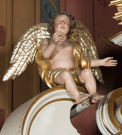 Zdjęcie nr 17: Nastawa architektoniczna, jednokondygnacyjna ze zwieńczeniem, jednoosiowa z bramkami, ustawiona na dwustrefowym cokole, z wyłamanymi pod kątem dwiema parami prostopadłościanów w górnej strefie. Ołtarz kamienny, prostopadłościenny, w drewnianej obudowie, z drewnianą mensą. Antepedium ujęte profilowaną ramą, w centrum medalion z krzyżem o trójlistnym zakończeniu ramion i promieniami na ich skrzyżowaniu, po bokach monogramy maryjny i IHS. Na ołtarzu tabernakulum z tronem wystawienia. Nastawa ujęta dwiema parami kolumn, przedzielonych dwiema parami filarów o kanelowanych trzonach, ustawionych pod kątem. Podpory dźwigają pełne belkowanie, wyłamane pod kątem na ich osi, przerwane nad polem środkowym oraz fragmenty przerwanego, półkolistego przyczółka z siedzącymi na nich puttami. Pomiędzy kolumnami ustawione figury św. Piotra i św. Pawła. W polu środkowym wnęka z obrazem św. Klemensa w formie stojącego prostokąta zakończona łukiem segmentowym z uskokiem, ujęta profilowaną ramą zwieńczoną dwiema zwróconymi ku sobie wolutami, podtrzymującymi koronę otwartą, flankowaną przez dwa putta. Kondygnacja ujęta uszami utworzonymi z suchego akantu i wstęgi. Zwieńczenie o kształcie zbliżonym do leżącego prostokąta, zamkniętego fragmentem segmentowo wyłamanego gzymsu, flankowanego spływami wolutowymi. Całe pole wypełnia obraz Zwiastowania, ujęty liśćmi. Zwieńczenie zakończone płaskorzeźbionym przedstawieniem Trójcy Świętej pośród obłoków i uskrzydlonych główek anielskich, w glorii promienistej. Bramki flankowane pilastrami o kanelowanych trzonach, podtrzymującymi nadproże wyłamane na kształt łuku kotarowego, zwieńczone kluczami z puttami. Na osi pilastrów ustawione po dwa wazony. Przejścia w formie stojącego prostokąta zamkniętego łukiem segmentowym nadwieszonym. Struktura polichromowana w kolorze białym; kolumny, profile i ornamentyka złocone, detal srebrzony. Z tyłu ołtarza ryta inskrypcja: „I.L.O.Z / 9/5 1845”.