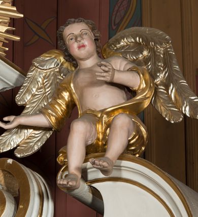 Zdjęcie nr 16: Nastawa architektoniczna, jednokondygnacyjna ze zwieńczeniem, jednoosiowa z bramkami, ustawiona na dwustrefowym cokole, z wyłamanymi pod kątem dwiema parami prostopadłościanów w górnej strefie. Ołtarz kamienny, prostopadłościenny, w drewnianej obudowie, z drewnianą mensą. Antepedium ujęte profilowaną ramą, w centrum medalion z krzyżem o trójlistnym zakończeniu ramion i promieniami na ich skrzyżowaniu, po bokach monogramy maryjny i IHS. Na ołtarzu tabernakulum z tronem wystawienia. Nastawa ujęta dwiema parami kolumn, przedzielonych dwiema parami filarów o kanelowanych trzonach, ustawionych pod kątem. Podpory dźwigają pełne belkowanie, wyłamane pod kątem na ich osi, przerwane nad polem środkowym oraz fragmenty przerwanego, półkolistego przyczółka z siedzącymi na nich puttami. Pomiędzy kolumnami ustawione figury św. Piotra i św. Pawła. W polu środkowym wnęka z obrazem św. Klemensa w formie stojącego prostokąta zakończona łukiem segmentowym z uskokiem, ujęta profilowaną ramą zwieńczoną dwiema zwróconymi ku sobie wolutami, podtrzymującymi koronę otwartą, flankowaną przez dwa putta. Kondygnacja ujęta uszami utworzonymi z suchego akantu i wstęgi. Zwieńczenie o kształcie zbliżonym do leżącego prostokąta, zamkniętego fragmentem segmentowo wyłamanego gzymsu, flankowanego spływami wolutowymi. Całe pole wypełnia obraz Zwiastowania, ujęty liśćmi. Zwieńczenie zakończone płaskorzeźbionym przedstawieniem Trójcy Świętej pośród obłoków i uskrzydlonych główek anielskich, w glorii promienistej. Bramki flankowane pilastrami o kanelowanych trzonach, podtrzymującymi nadproże wyłamane na kształt łuku kotarowego, zwieńczone kluczami z puttami. Na osi pilastrów ustawione po dwa wazony. Przejścia w formie stojącego prostokąta zamkniętego łukiem segmentowym nadwieszonym. Struktura polichromowana w kolorze białym; kolumny, profile i ornamentyka złocone, detal srebrzony. Z tyłu ołtarza ryta inskrypcja: „I.L.O.Z / 9/5 1845”.