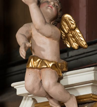 Zdjęcie nr 21: Nastawa architektoniczna, jednokondygnacyjna ze zwieńczeniem, jednoosiowa z bramkami, ustawiona na dwustrefowym cokole, z wyłamanymi pod kątem dwiema parami prostopadłościanów w górnej strefie. Ołtarz kamienny, prostopadłościenny, w drewnianej obudowie, z drewnianą mensą. Antepedium ujęte profilowaną ramą, w centrum medalion z krzyżem o trójlistnym zakończeniu ramion i promieniami na ich skrzyżowaniu, po bokach monogramy maryjny i IHS. Na ołtarzu tabernakulum z tronem wystawienia. Nastawa ujęta dwiema parami kolumn, przedzielonych dwiema parami filarów o kanelowanych trzonach, ustawionych pod kątem. Podpory dźwigają pełne belkowanie, wyłamane pod kątem na ich osi, przerwane nad polem środkowym oraz fragmenty przerwanego, półkolistego przyczółka z siedzącymi na nich puttami. Pomiędzy kolumnami ustawione figury św. Piotra i św. Pawła. W polu środkowym wnęka z obrazem św. Klemensa w formie stojącego prostokąta zakończona łukiem segmentowym z uskokiem, ujęta profilowaną ramą zwieńczoną dwiema zwróconymi ku sobie wolutami, podtrzymującymi koronę otwartą, flankowaną przez dwa putta. Kondygnacja ujęta uszami utworzonymi z suchego akantu i wstęgi. Zwieńczenie o kształcie zbliżonym do leżącego prostokąta, zamkniętego fragmentem segmentowo wyłamanego gzymsu, flankowanego spływami wolutowymi. Całe pole wypełnia obraz Zwiastowania, ujęty liśćmi. Zwieńczenie zakończone płaskorzeźbionym przedstawieniem Trójcy Świętej pośród obłoków i uskrzydlonych główek anielskich, w glorii promienistej. Bramki flankowane pilastrami o kanelowanych trzonach, podtrzymującymi nadproże wyłamane na kształt łuku kotarowego, zwieńczone kluczami z puttami. Na osi pilastrów ustawione po dwa wazony. Przejścia w formie stojącego prostokąta zamkniętego łukiem segmentowym nadwieszonym. Struktura polichromowana w kolorze białym; kolumny, profile i ornamentyka złocone, detal srebrzony. Z tyłu ołtarza ryta inskrypcja: „I.L.O.Z / 9/5 1845”.