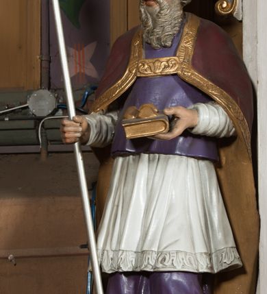 Zdjęcie nr 8: Nastawa architektoniczna, jednoosiowa, jednokondygnacyjna ze zwieńczeniem, ustawiona na dwustrefowym cokole, w górnej części z wyłamanymi pod kątem dwoma prostopadłościanami. Ołtarz drewniany, prostopadłościenny, skrzyniowy, z drewnianą mensą. Antepedium ujęte profilowaną ramą, w polu dwie duże, płaskorzeźbione rozety na pomarańczowym tle. Nastawa ujęta parą kolumn ustawionych na tle pilastrów, dźwigających pełne belkowanie, wyłamane pod kątem na ich osi, częściowo przerwane nad polem środkowym oraz fragmenty przerwanego półkolistego przyczółka. Pole centralne w całości wypełnione wnęką w formie stojącego prostokąta zamkniętego łukiem segmentowym nadwieszonym, ujętym profilowaną ramą, z obrazem św. Antoniego Padewskiego. Nad nim akantowy kartusz, z przedstawieniem dwóch skrzyżowanych kluczy w polu. Kondygnację flankują dwie figury biskupów ustawione na wysuniętych krawędziach cokołu oraz uszy utworzone z suchego akantu i wstęgi. Zwieńczenie w formie zbliżonej do trapezu zamkniętego fragmentem gzymsu o kształcie łuku segmentowego z uskokiem, flankowanego spływami wolutowymi. W polu obraz św. Antoniego Padewskiego w formie stojącego owalu, ujęty profilowaną ramą, u góry dekorowany zwisami kwiatowymi, u dołu liśćmi. Całość zakończona figurką św. Michała Archanioła trzymającego w uniesionej ręce miecz. Struktura polichromowana w kolorze białym; kolumny, profile i ornamentyka złocone, detal srebrzony. 


