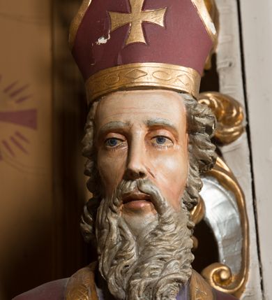 Zdjęcie nr 10: Nastawa architektoniczna, jednoosiowa, jednokondygnacyjna ze zwieńczeniem, ustawiona na dwustrefowym cokole, w górnej części z wyłamanymi pod kątem dwoma prostopadłościanami. Ołtarz drewniany, prostopadłościenny, skrzyniowy, z drewnianą mensą. Antepedium ujęte profilowaną ramą, w polu dwie duże, płaskorzeźbione rozety na pomarańczowym tle. Nastawa ujęta parą kolumn ustawionych na tle pilastrów, dźwigających pełne belkowanie, wyłamane pod kątem na ich osi, częściowo przerwane nad polem środkowym oraz fragmenty przerwanego półkolistego przyczółka. Pole centralne w całości wypełnione wnęką w formie stojącego prostokąta zamkniętego łukiem segmentowym nadwieszonym, ujętym profilowaną ramą, z obrazem św. Antoniego Padewskiego. Nad nim akantowy kartusz, z przedstawieniem dwóch skrzyżowanych kluczy w polu. Kondygnację flankują dwie figury biskupów ustawione na wysuniętych krawędziach cokołu oraz uszy utworzone z suchego akantu i wstęgi. Zwieńczenie w formie zbliżonej do trapezu zamkniętego fragmentem gzymsu o kształcie łuku segmentowego z uskokiem, flankowanego spływami wolutowymi. W polu obraz św. Antoniego Padewskiego w formie stojącego owalu, ujęty profilowaną ramą, u góry dekorowany zwisami kwiatowymi, u dołu liśćmi. Całość zakończona figurką św. Michała Archanioła trzymającego w uniesionej ręce miecz. Struktura polichromowana w kolorze białym; kolumny, profile i ornamentyka złocone, detal srebrzony. 


