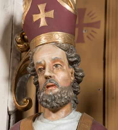 Zdjęcie nr 13: Nastawa architektoniczna, jednoosiowa, jednokondygnacyjna ze zwieńczeniem, ustawiona na dwustrefowym cokole, w górnej części z wyłamanymi pod kątem dwoma prostopadłościanami. Ołtarz drewniany, prostopadłościenny, skrzyniowy, z drewnianą mensą. Antepedium ujęte profilowaną ramą, w polu dwie duże, płaskorzeźbione rozety na pomarańczowym tle. Nastawa ujęta parą kolumn ustawionych na tle pilastrów, dźwigających pełne belkowanie, wyłamane pod kątem na ich osi, częściowo przerwane nad polem środkowym oraz fragmenty przerwanego półkolistego przyczółka. Pole centralne w całości wypełnione wnęką w formie stojącego prostokąta zamkniętego łukiem segmentowym nadwieszonym, ujętym profilowaną ramą, z obrazem św. Antoniego Padewskiego. Nad nim akantowy kartusz, z przedstawieniem dwóch skrzyżowanych kluczy w polu. Kondygnację flankują dwie figury biskupów ustawione na wysuniętych krawędziach cokołu oraz uszy utworzone z suchego akantu i wstęgi. Zwieńczenie w formie zbliżonej do trapezu zamkniętego fragmentem gzymsu o kształcie łuku segmentowego z uskokiem, flankowanego spływami wolutowymi. W polu obraz św. Antoniego Padewskiego w formie stojącego owalu, ujęty profilowaną ramą, u góry dekorowany zwisami kwiatowymi, u dołu liśćmi. Całość zakończona figurką św. Michała Archanioła trzymającego w uniesionej ręce miecz. Struktura polichromowana w kolorze białym; kolumny, profile i ornamentyka złocone, detal srebrzony. 


