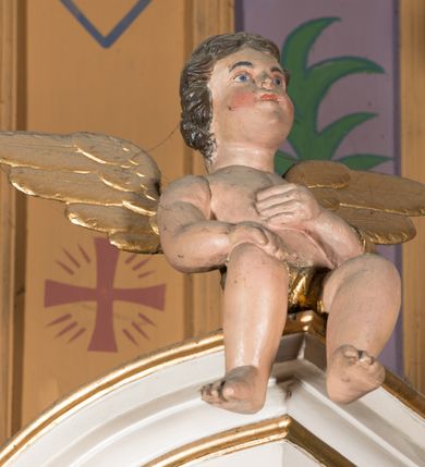 Zdjęcie nr 8: Nastawa architektoniczna, jednoosiowa, jednokondygnacyjna ze zwieńczeniem, ustawiona na dwustrefowym cokole, w górnej części z wyłamanymi pod kątem dwoma prostopadłościanami. Ołtarz drewniany, prostopadłościenny, skrzyniowy, z drewnianą mensą. Antepedium ujęte profilowaną ramą, w polu dwie, duże, płaskorzeźbione rozety na pomarańczowym tle. Nastawa ujęta parą kolumn ustawionych na tle pilastrów, dźwigających pełne belkowanie, wyłamane pod kątem na ich osi, częściowo przerwane nad polem środkowym, oraz fragmenty przerwanego półkolistego przyczółka z puttami. Pole centralne w całości wypełnione wnęką w formie stojącego prostokąta zamkniętego łukiem segmentowym nadwieszonym, ujętym profilowaną ramą, z wpisanym krucyfiksem na tle malowanych obłoków. Nad nim akantowo-wstęgowy kartusz, z napisem „OJCZE! / odpuść im / bo niewiedzą / co czynią”. Kondygnację flankują figury Matki Boskiej i św. Jana ustawione na wysuniętych krawędziach cokołu oraz uszy utworzone z suchego akantu i wstęgi. Zwieńczenie w formie zbliżonej do trapezu zamkniętego fragmentem gzymsu o kształcie łuku segmentowego z uskokiem, flankowanego spływami wolutowymi. W polu obraz Piety w formie stojącego owalu, ujęty profilowaną ramą, u góry dekorowany zwisami kwiatowymi, u dołu liśćmi. Całość zakończona figurą Anioła Stróża. Struktura polichromowana w kolorze białym; kolumny, profile i ornamentyka złocone, detal srebrzony. 