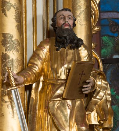 Zdjęcie nr 1: Rzeźba wydrążona z tyłu, ustawiona na nieregularnej podstawie. Święty ukazany frontalnie, w kontrapoście, w prawej, wyciągniętej w bok ręce trzyma miecz zwrócony ostrzem w dół, w lewej, ugiętej, trzyma księgę. Twarz ma szczupłą, kwadratową, o starczych rysach, migdałowatych oczach, garbatym nosie i otwartych ustach z widoczną linią zębów. Twarz ma okoloną długą, silnie kręconą brodą oraz krótkimi, falowanymi włosami. Ubrany jest w złoconą tunikę, przepasaną w talii oraz złocony płaszcz zarzucony na lewe przedramię i bok. Polichromia ciała naturalistyczna, włosy i broda ciemnobrązowe. 

