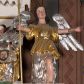 Zdjęcie nr 1: Figura pełnoplastyczna. Anioł ukazany frontalnie, z ugiętą lewą nogą. Obie ręce ma rozłożone na boki, w prawej trzyma włócznię. Twarz ma owalną, o pełnych policzkach, dużych oczach, zadartym nosie i rozchylonych ustach; okoloną falowanymi włosami opadającymi na ramiona. Ubrany jest w srebrzoną suknię spodnią, sięgającą ziemi, odsłaniającą lewą nogę oraz krótszą szatę wierzchnią, złoconą, o szerokich rękawach, przepasaną w talii. Skrzydła ma srebrzone, rozłożone na boki. Polichromia ciała naturalistyczna, włosy brązowe. 

