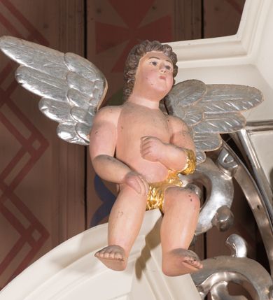 Zdjęcie nr 8: Nastawa architektoniczna, jednoosiowa, jednokondygnacyjna ze zwieńczeniem, ustawiona na dwustrefowym cokole, w górnej strefie z wyodrębnionymi dwoma prostopadłościanami. Ołtarz drewniany, prostopadłościenny, z drewnianą mensą. Antepedium ujęte profilowaną ramą z godłem franciszkanów (krzyż między skrzyżowanymi dłońmi) na czerwonym tle. Nastawa flankowana parą kolumn o kapitelach kompozytowych stojących na tle zwielokrotnionych pilastrów. Kolumny wspierają belkowanie wyłamane na ich osi oraz fragmenty falistego, przerwanego przyczółka z siedzącymi puttami. Pośrodku belkowania kartusz ujęty wieńcem laurowym z napisem „O Boże najczystsza / miłości! rozgrzej mię, / straw mię. S(więty) Aug(ustyn)”. Całe pole główne wypełnione wnęką w formie stojącego prostokąta, ujętego profilowaną ramą, z obrazem przedstawiającym św. Franciszka przed Chrystusem i Marią. Kondygnacja flankowana niewielkimi uszami utworzonymi ze stylizowanego akantu i wstęgi. Zwieńczenie w formie zbliżonej do kwadratu, o wklęsłych bokach dekorowanych ornamentem roślinnym, zamkniętego fragmentem gzymsu o kształcie łuku półkolistego nadwieszonego. W polu obraz św. Marii Magdaleny o tej samej formie, w profilowanej ramie. Obraz ujęty z trzech stron zwisami roślinnymi. Nastawa flankowana figurami św. Franciszka i św. Antoniego Padewskiego ustawionymi na wspornikach przy ścianie. Struktura polichromowana w kolorze białym, kolumny, profile złocone; ornamentyka złocona i srebrzona. 


